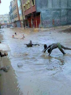 أطفال القليعة بإنزكان يحولون مجاري المياه التي شكلتها الأمطار إلى مسابح عمومية