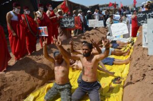 +صور:تجار سوق البلاستيك يرتدون الأكفان ويحتجون من داخل القبور بإنزكان