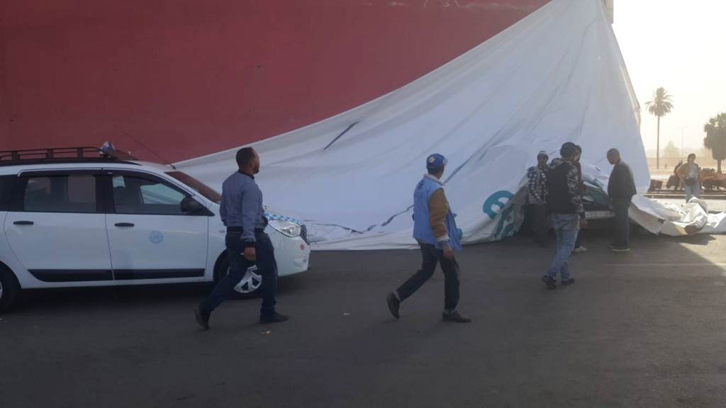 بالصورة: الرياح القوية تسقط قطعة من لوحة إشهارية على سيارات الأجرة بإنزكان.