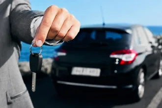 مفتاح سيارة أمام مركبة معدة للكراء في مشهد يعبر عن قطاع كراء السيارات
